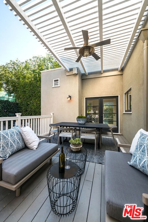 wooden deck featuring ceiling fan, an outdoor living space, and a pergola