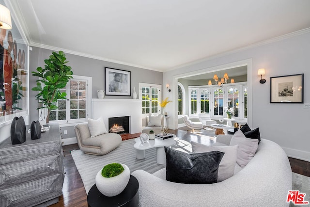 living room featuring a notable chandelier, ornamental molding, plenty of natural light, and dark hardwood / wood-style flooring