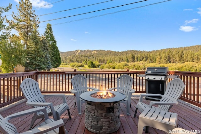 wooden terrace with a grill and an outdoor fire pit