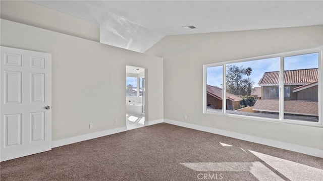 empty room with carpet floors, plenty of natural light, visible vents, and vaulted ceiling