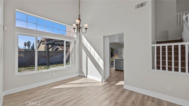 foyer featuring a high ceiling, light hardwood / wood-style flooring, and a notable chandelier