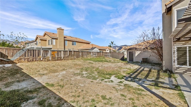 view of yard featuring central AC unit and a fenced backyard