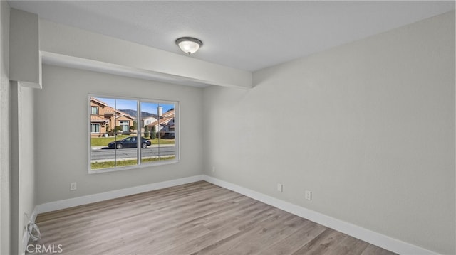 unfurnished room featuring wood finished floors and baseboards