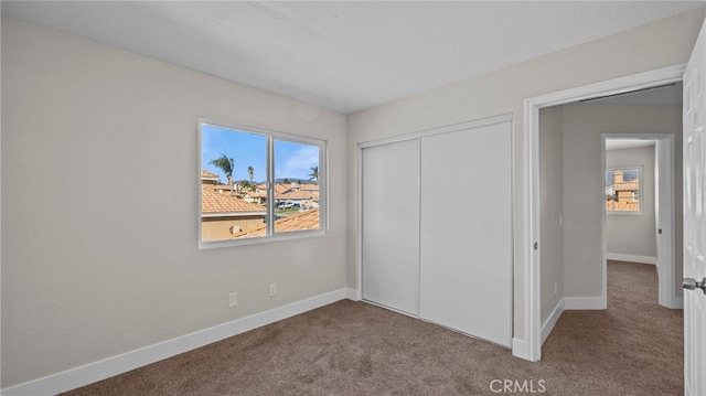 unfurnished bedroom featuring carpet floors and a closet