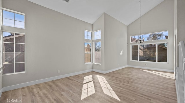 interior space with an inviting chandelier, high vaulted ceiling, and light hardwood / wood-style floors