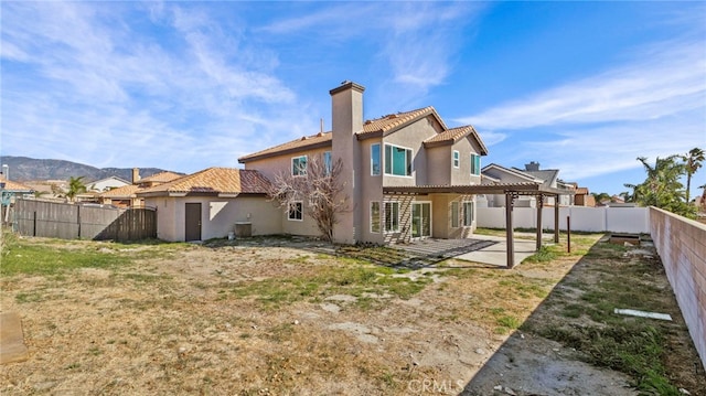 back of property with a yard, a pergola, a patio, and a mountain view