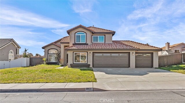 mediterranean / spanish home featuring a garage and a front yard