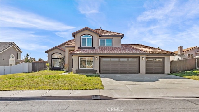 mediterranean / spanish house with a tile roof, fence, concrete driveway, stucco siding, and a front lawn