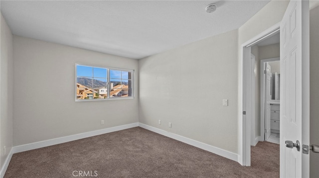 carpeted spare room featuring a textured ceiling