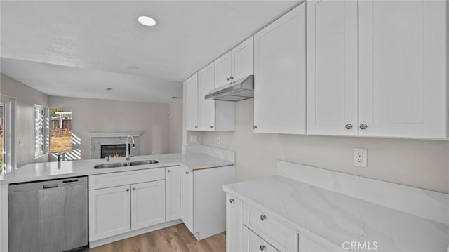 kitchen with stainless steel dishwasher, kitchen peninsula, sink, and white cabinets