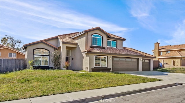 mediterranean / spanish home featuring a tile roof, stucco siding, concrete driveway, fence, and a front lawn