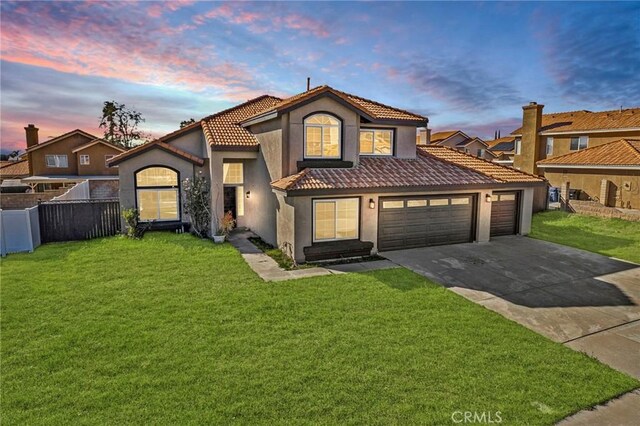 mediterranean / spanish home featuring a lawn and a garage