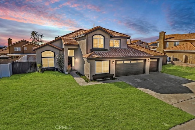 mediterranean / spanish home featuring a garage and a lawn