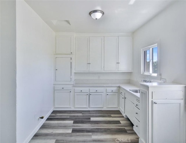 kitchen with white cabinets, dark wood-type flooring, and sink