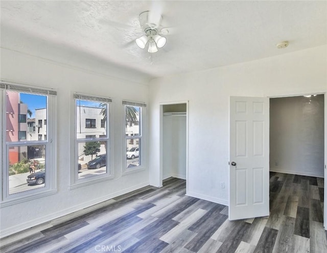 empty room featuring ceiling fan and dark wood-type flooring