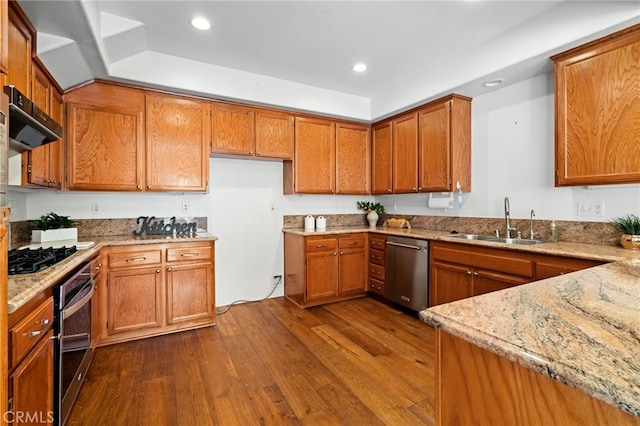 kitchen with stainless steel appliances, light stone countertops, sink, and dark hardwood / wood-style floors