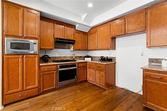 kitchen featuring appliances with stainless steel finishes, light stone counters, and dark hardwood / wood-style flooring