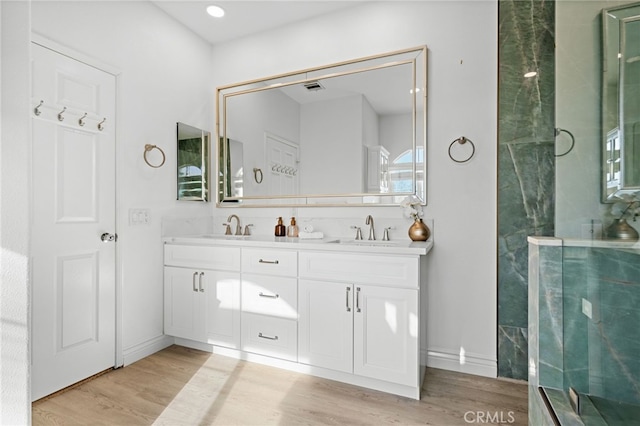 bathroom featuring a shower with door, vanity, and hardwood / wood-style floors