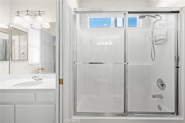 bathroom featuring bath / shower combo with glass door and vanity