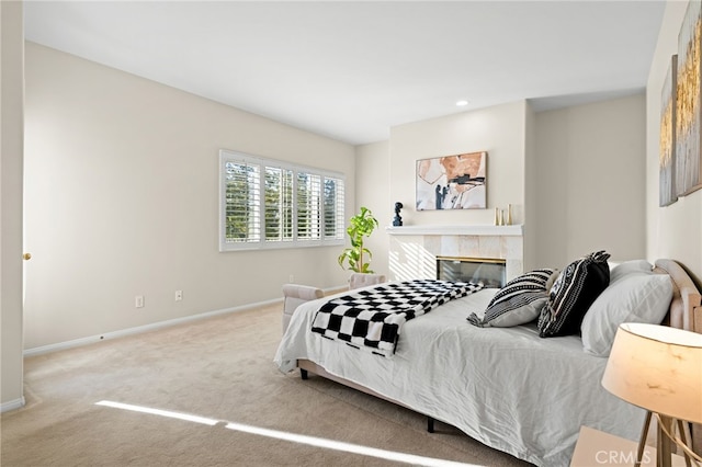 bedroom with a tile fireplace and carpet flooring