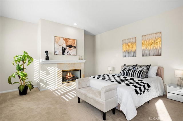 bedroom featuring a tile fireplace and carpet flooring