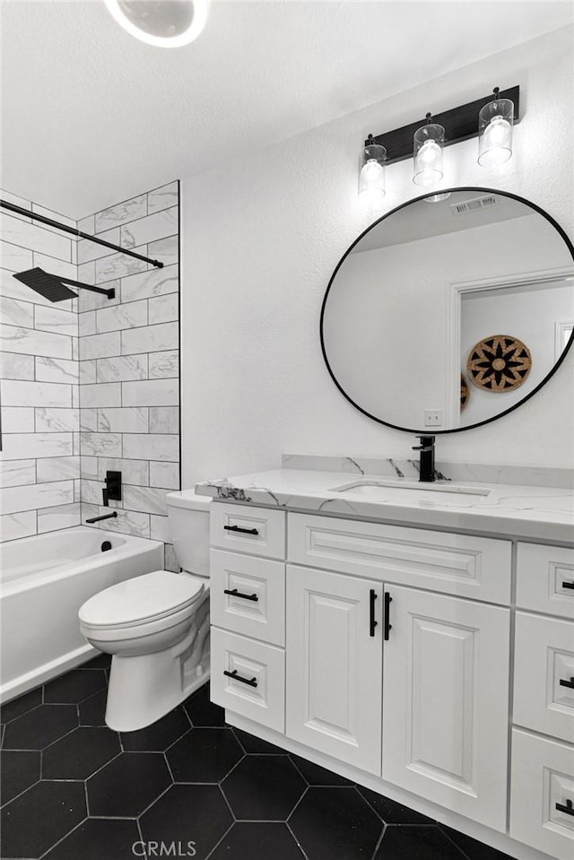 full bathroom with toilet, a textured ceiling, tiled shower / bath combo, tile patterned flooring, and vanity