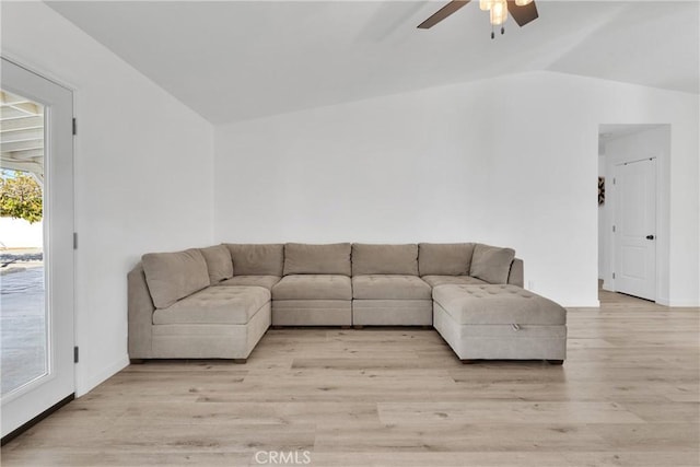 unfurnished living room featuring lofted ceiling, light wood-type flooring, ceiling fan, and plenty of natural light