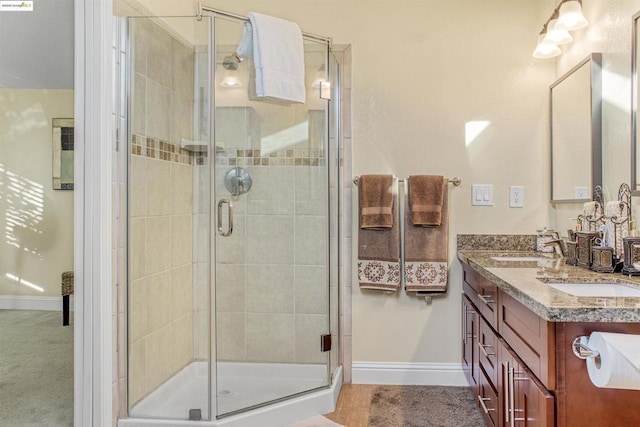 bathroom with a shower with door and vanity