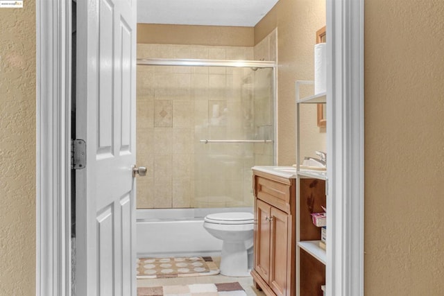 full bathroom featuring combined bath / shower with glass door, toilet, and vanity