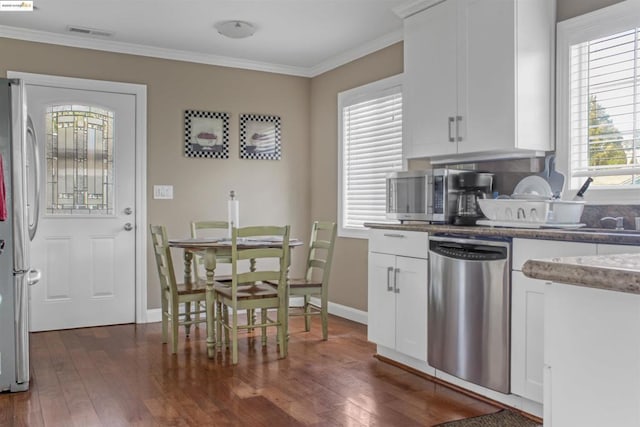 kitchen featuring crown molding, white cabinets, dark wood-type flooring, and appliances with stainless steel finishes