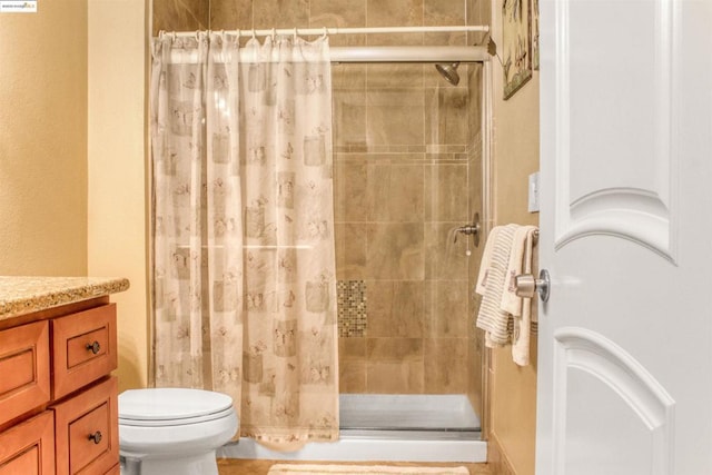 bathroom featuring vanity, toilet, and walk in shower