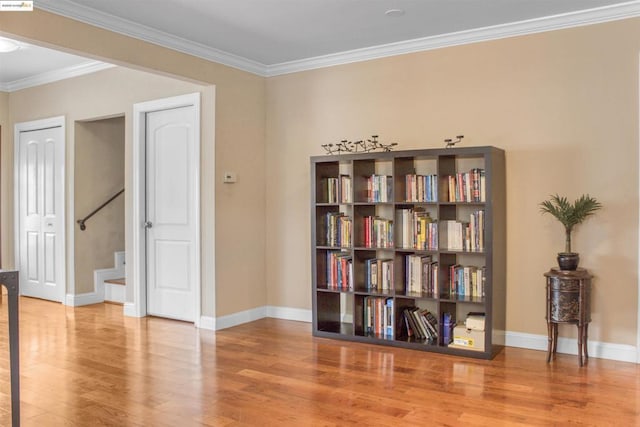 living area featuring crown molding and hardwood / wood-style flooring