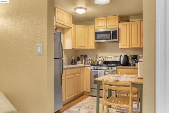 kitchen featuring light brown cabinets, light hardwood / wood-style flooring, sink, a textured ceiling, and stainless steel appliances