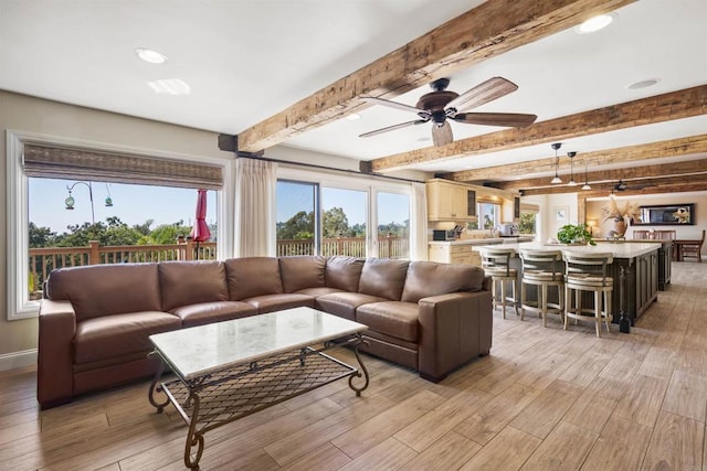 living room featuring ceiling fan and beam ceiling