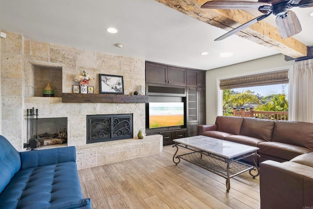 living room with ceiling fan, a fireplace, and light hardwood / wood-style flooring