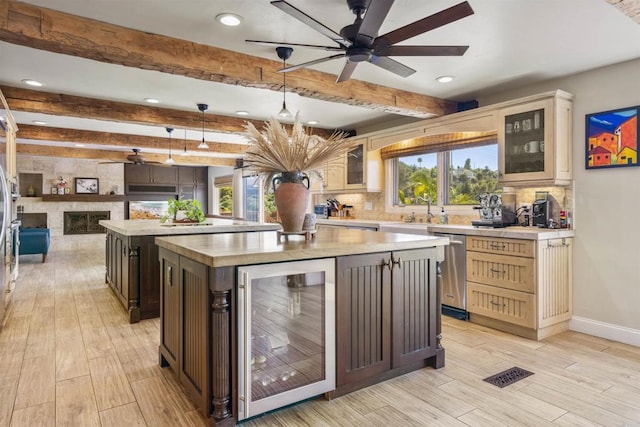 kitchen featuring wine cooler, pendant lighting, a kitchen island, beamed ceiling, and decorative backsplash