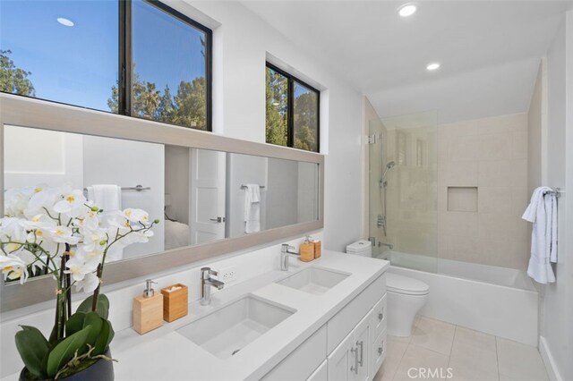 full bathroom with tiled shower / bath, tile patterned floors, toilet, and vanity