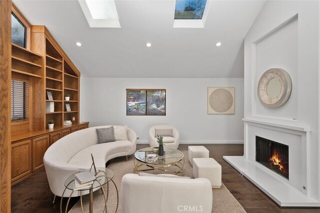 living room with a lit fireplace, vaulted ceiling with skylight, dark wood finished floors, and recessed lighting