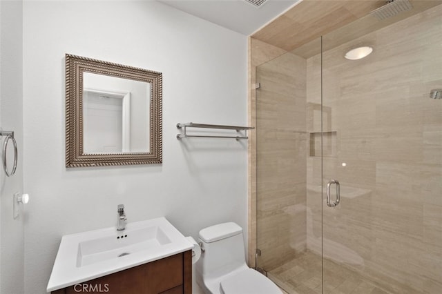 full bathroom featuring vanity, a shower stall, and toilet