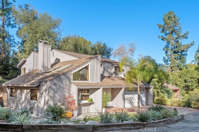 rear view of property with a garage