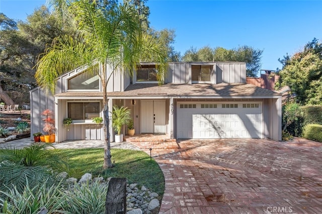 view of front of property with a garage, decorative driveway, and board and batten siding