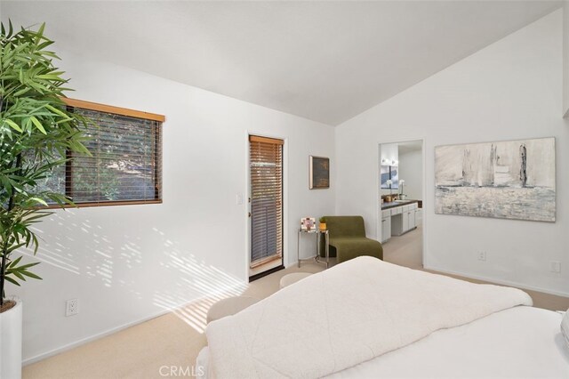 bedroom with light carpet, lofted ceiling, and ensuite bathroom