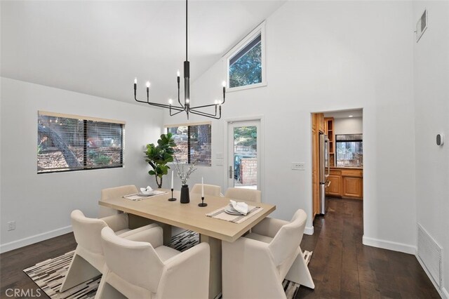 dining space featuring dark hardwood / wood-style flooring, high vaulted ceiling, and a chandelier