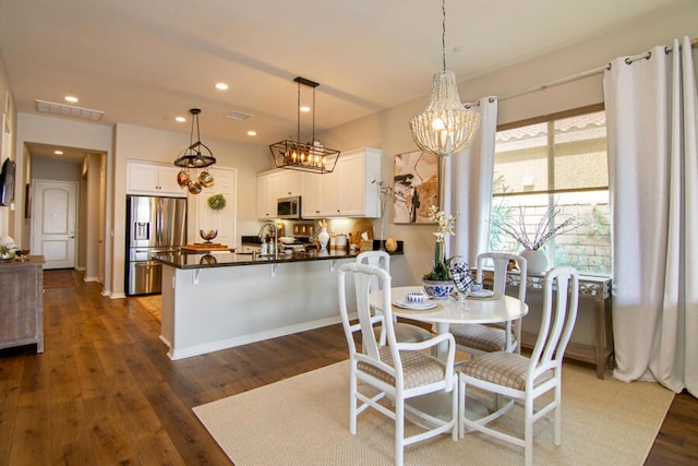 dining space with dark hardwood / wood-style floors and a notable chandelier