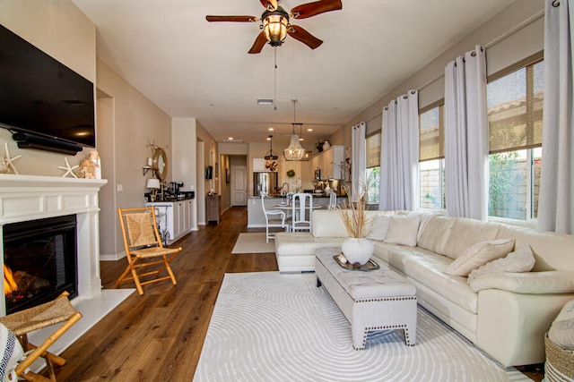 living room with dark hardwood / wood-style flooring, plenty of natural light, and ceiling fan