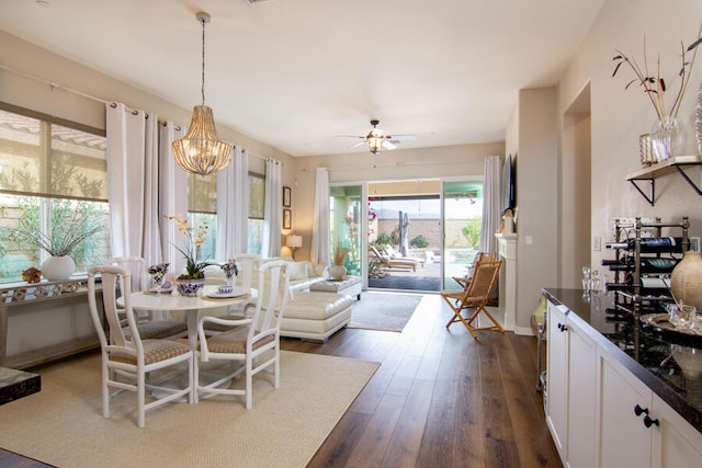 dining space featuring dark hardwood / wood-style floors and ceiling fan with notable chandelier