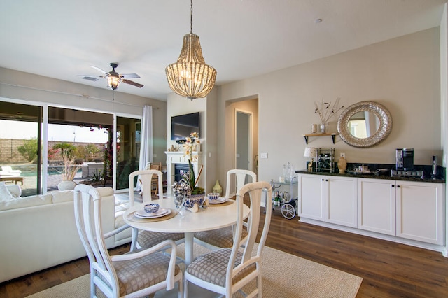 dining space featuring ceiling fan with notable chandelier and dark hardwood / wood-style floors