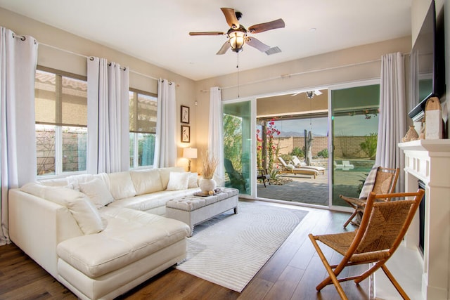 living room featuring dark wood-type flooring and ceiling fan