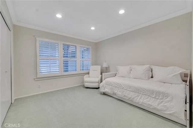 carpeted bedroom with a closet and crown molding