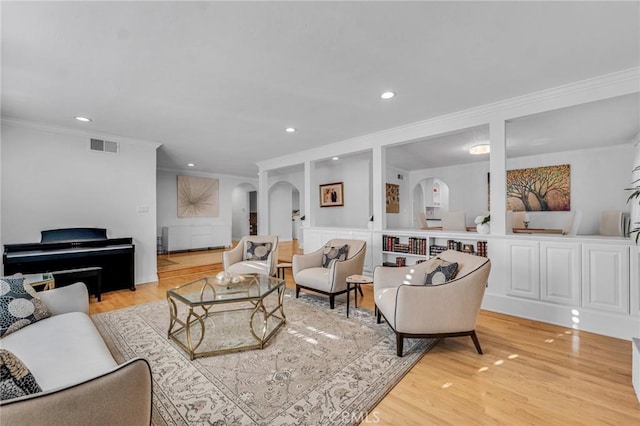 living room featuring ornamental molding and light hardwood / wood-style flooring